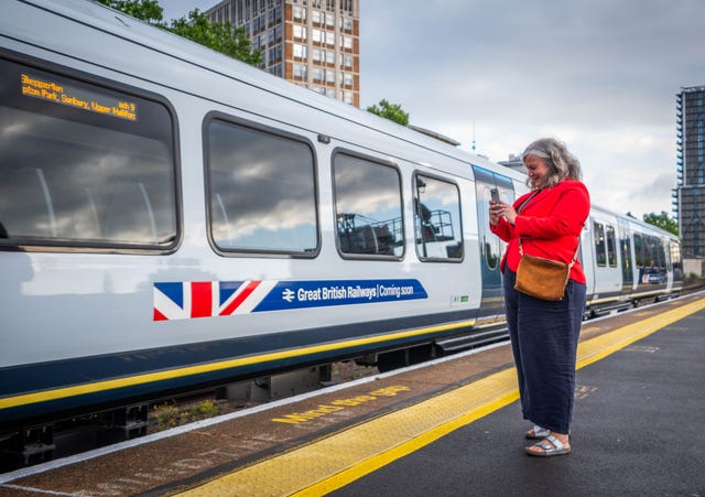 Heidi Alexander takes a photo next to a Great British Railways train