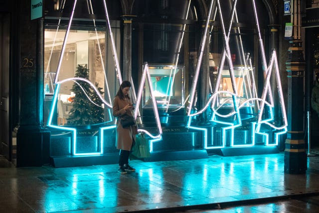 Shoppers pass Christmas light displays on New Bond Street in central London