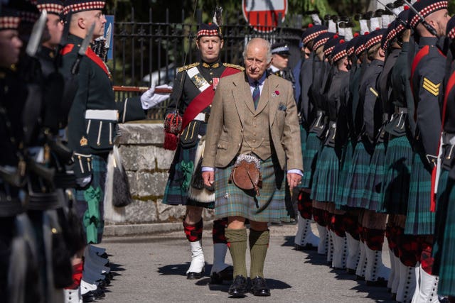 The King walking between two lines of soldiers