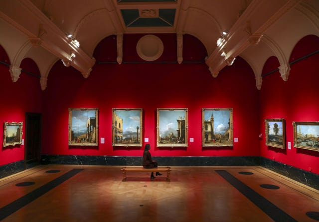 A woman looks at paintings by the Italian artist Canaletto