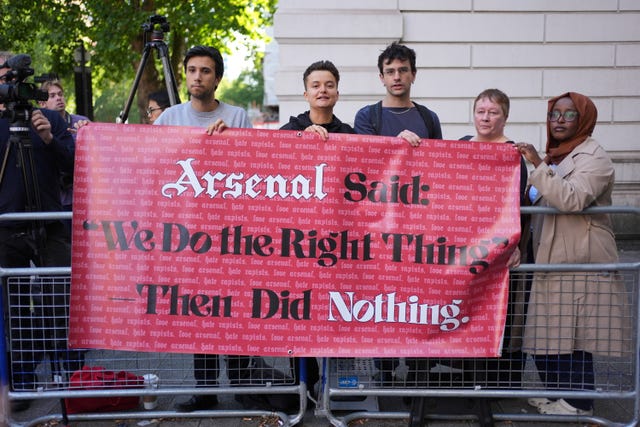 People from Arsenal Supporters Against Sexual Violence held a banner outside the court
