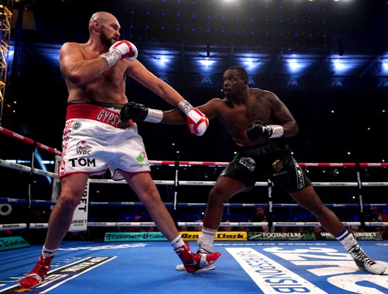 Dillian Whyte, right, throws a southpaw jab to the body of Tyson Fury