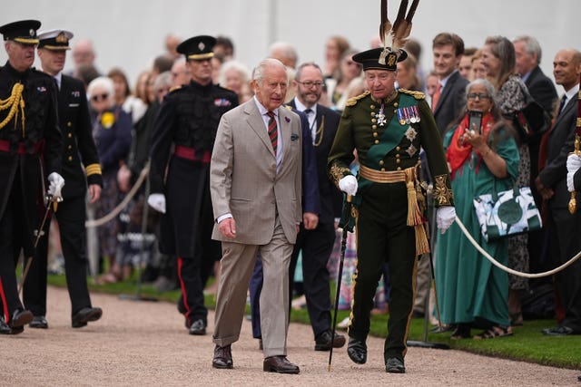 The King walking amongst several people in military uniform