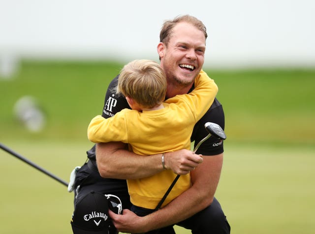 Danny Willett gets a hug from son Zachariah James after winning