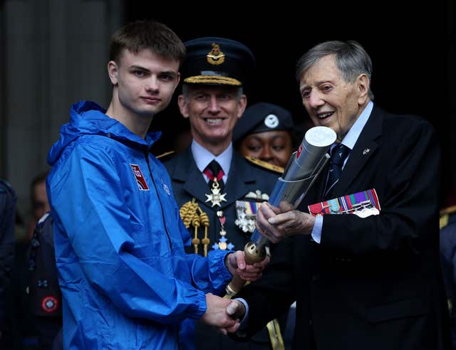 Aircraftsman Adam Wood, 16, is handed the baton by Royal Air Force veteran Air Commodore Charles Clarke outside the Royal Courts of Justice in London (Steven Paston/PA)
