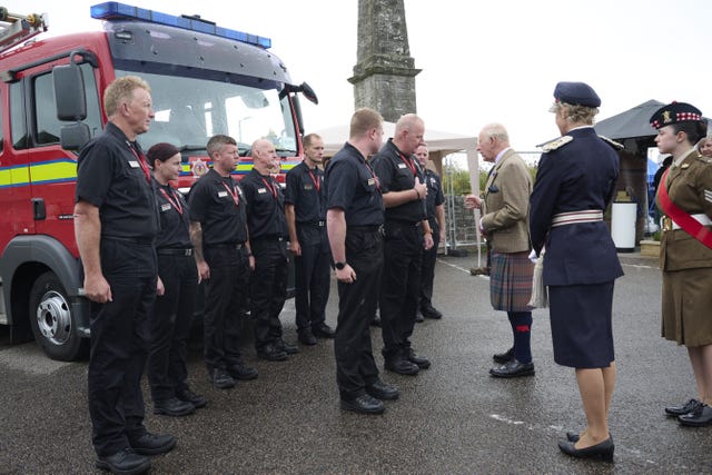Charles meeting firefighters standing in front of a fire engine