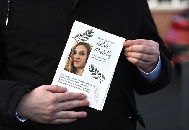 A mourner holds an order of service during Natalie McNally's funeral in 2022