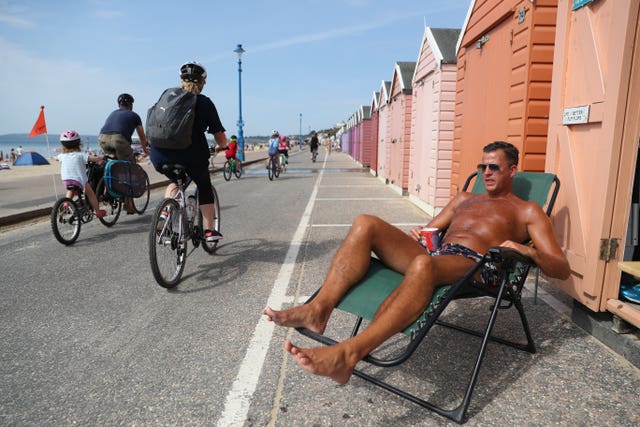 Stuart (no surname given) soaks up some rays outside a beach hut at Bournemouth on August 8