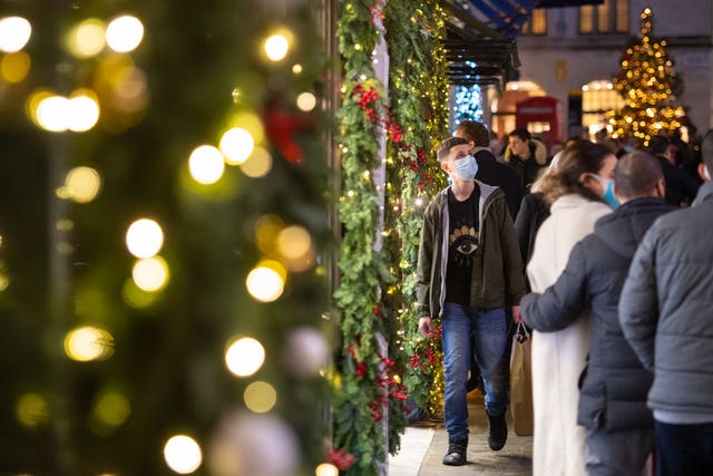 Shoppers pass Christmas light displays on New Bond Street in central London