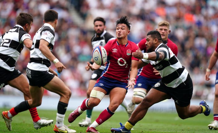 England’s Marcus Smith, centre, is tackled by Barbarians’ Sipili Falatea
