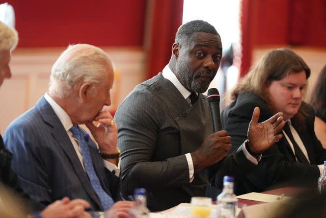 The King listening as Idris Elba speaks at a roundtable discussion