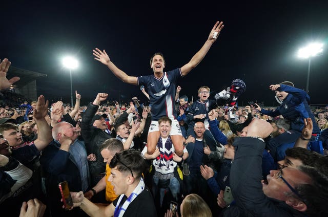 Liam Henderson celebrates winning the league on top of the shoulders of fans