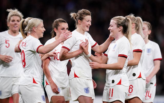 Bethany England, left, celebrates after getting the final touch to an effort from Lauren Hemp, right