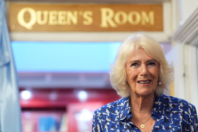 Camilla marking their 90th anniversary with the queen's room plaque behind