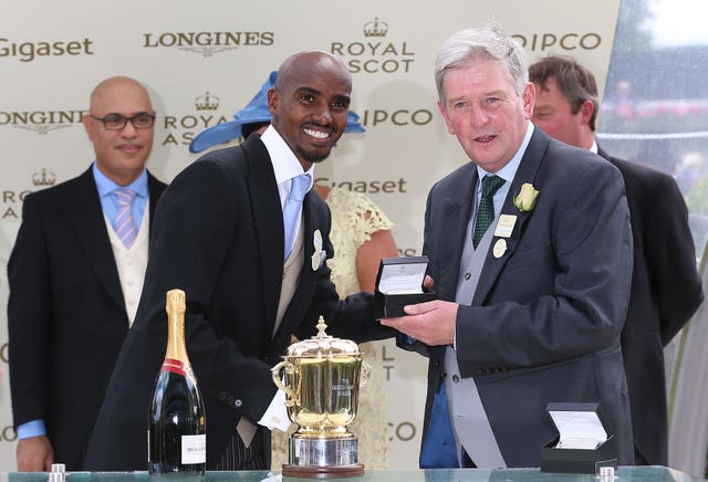 Sir Mo Farah presents John Quinn with his prize after Signora Cabello's win. Quinn has been reward with seven more horses