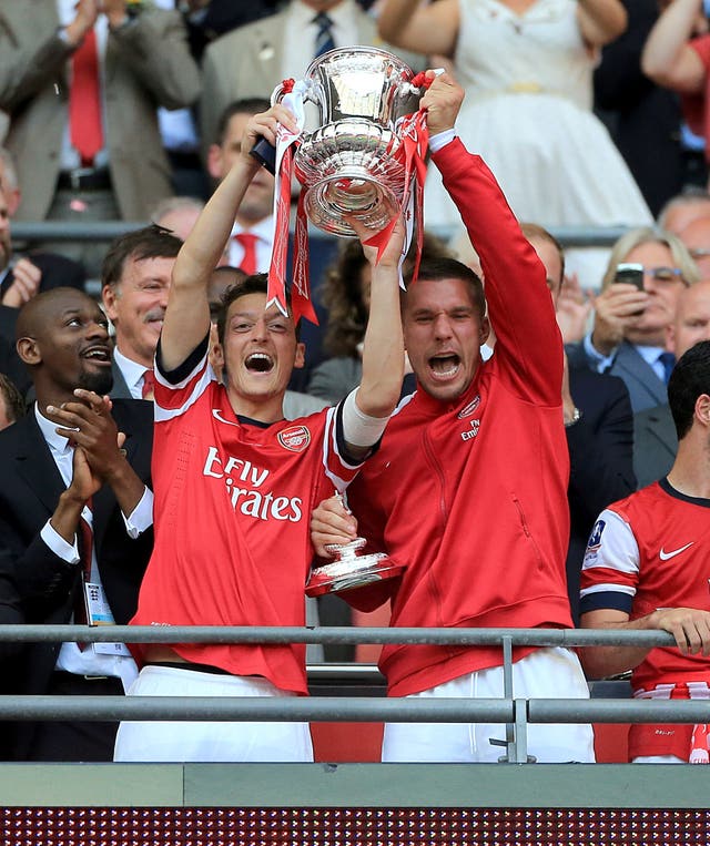 Ozil (left) helped Arsenal win the FA Cup three times (Nick Potts/PA).