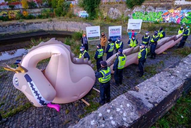 Police officers guarding an inflatable Loch Ness Monster at Govan Dry Dock (Jess Hurd/PA)