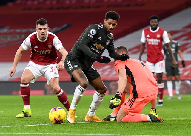 Manchester United’s Marcus Rashford battles for the ball with Arsenal’s Granit Xhaka and goalkeeper Bernd Leno