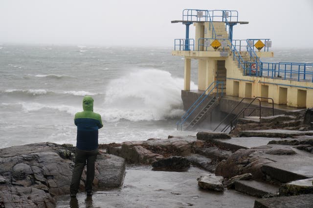 A person viewing rough seas from rocks
