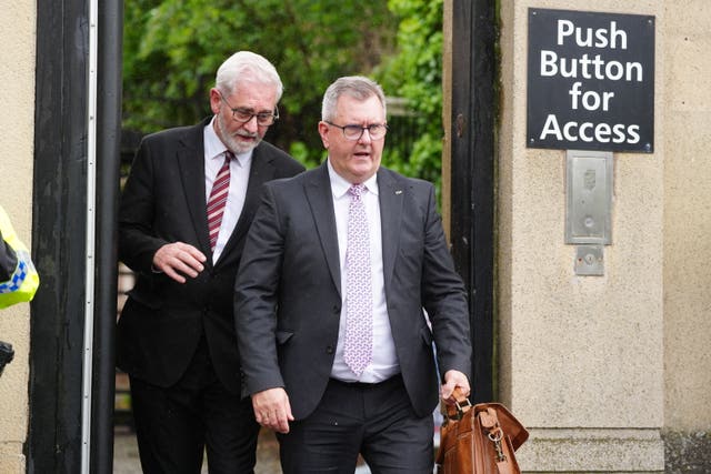 Jeffrey Donaldson exiting a building, walking alongside another man