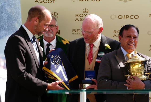 The Prince of Wales presents a commemorative saddle blanket to trainer John Gosden following his 70th win at Royal Ascot with Ombudsman