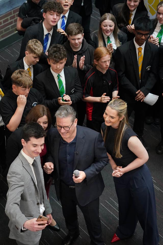 Sir Keir Starmer and Labour parliamentary candidate for Kettering Rosie Wrighting pose for a selfie during a visit to a school in Northamptonshire
