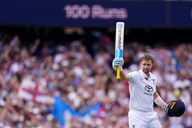 Joe Root raises his bat as the SCG scoreboard displays '100 runs'