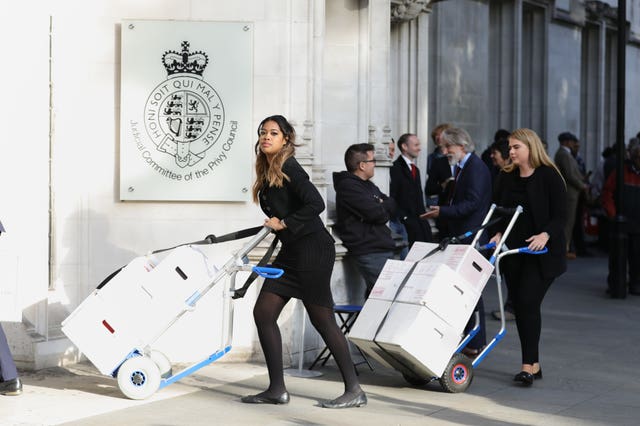 Boxes of legal documents are wheeled in to the Supreme Court