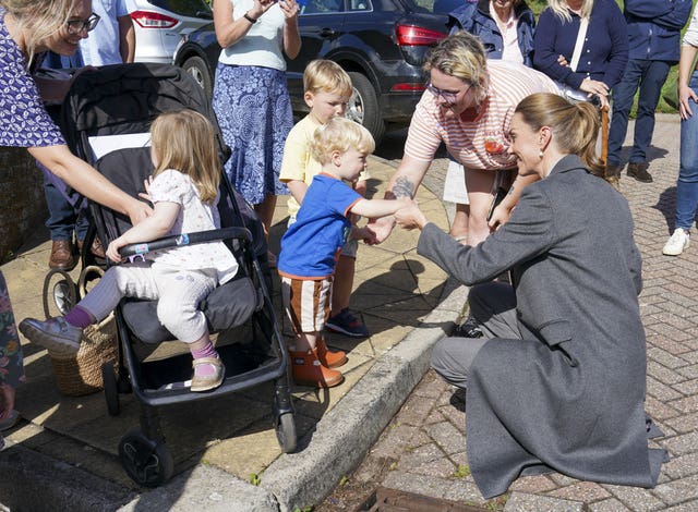 Kate helps one-year-old Albie Botley-Greenslade jump from a kerb in Pulborough, West Sussex