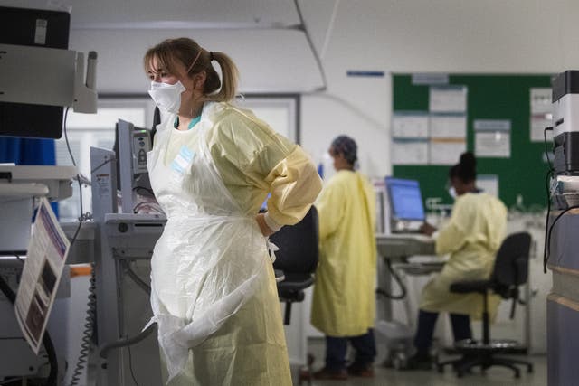 A nurse adjusts her PPE in the Intensive Care Unit