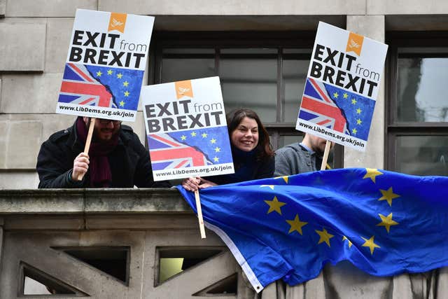 Former Lib Dem MP Sarah Olney joins protesters on the second floor balcony at Lib Dem headquarters next door to the Policy Exchange in London ahead of Mr Johnson's speech (Dominic Lipinski/PA)