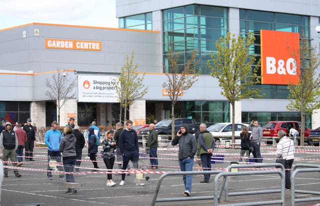 Members of the public follow social distancing guidelines and queue in the car park of B&Q