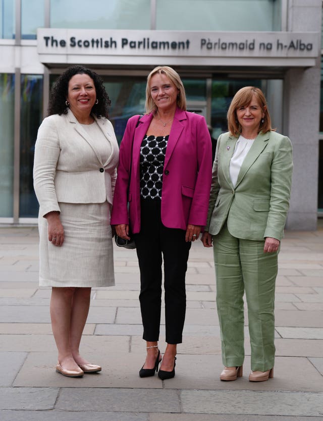 Sandie Peggie, Maya Forstater and Margaret Gribbon smiling while standing outside the Scottish Parliament