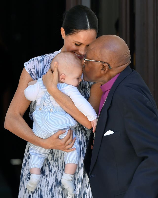 Baby Archie is kissed by Desmond Tutu while in the arms of his mother the Duchess of Sussex, in Cape Town