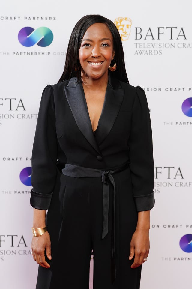 Angellica Bell smiling in front of Bafta TV awards signage