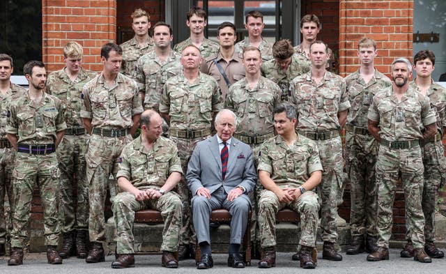 The King, as Colonel-in-Chief and the Company Commander of The King’s Company, Grenadier Guards, sits with troops for a photograph during a visit to 1st Battalion Grenadier Guards at Lille Barracks in Aldershot, ahead of their participation in Trooping the Colour, the King’s official birthday parade