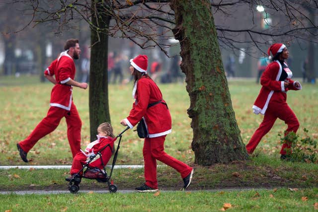 Strolling Santas brave the rain and cold in Clapham Common, south west London