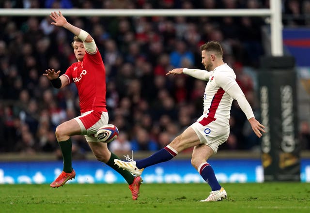 Elliot Daly, right, kicks under pressure from Wales try-scorer Nick Tompkins