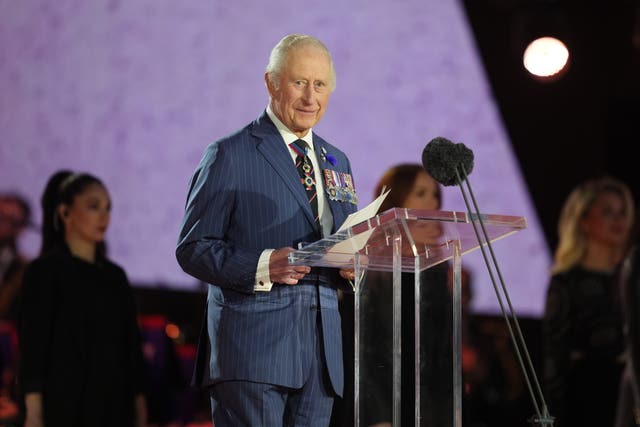King Charles speaking from a podium, wearing medals