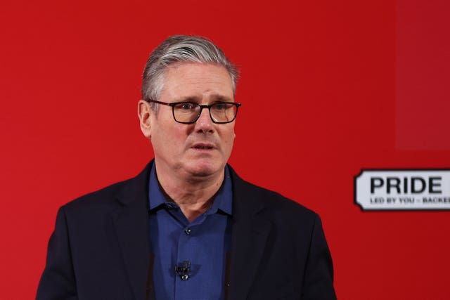 Sir Keir Starmer speaking, in front of a red wall