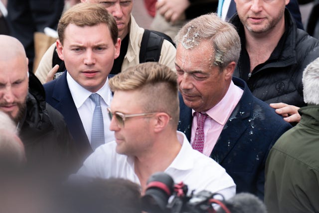 Nigel Farage with George Cottrell, left, as Mr Farage had a milkshake thrown over him