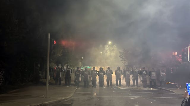 Police with shields form a line near protesters