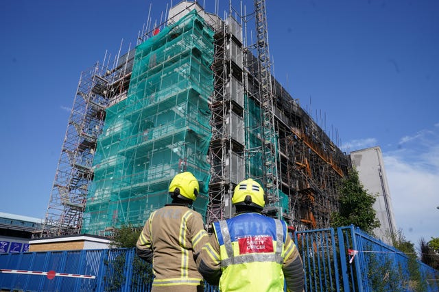 Safety officers look at the aftermath of a Dagenham flat fire
