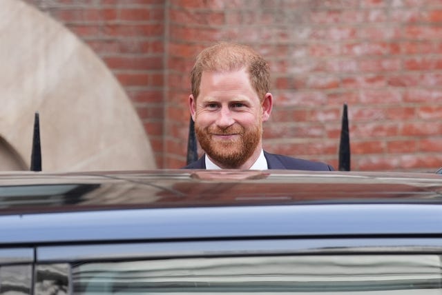 Duke of Sussex smiling beside a car
