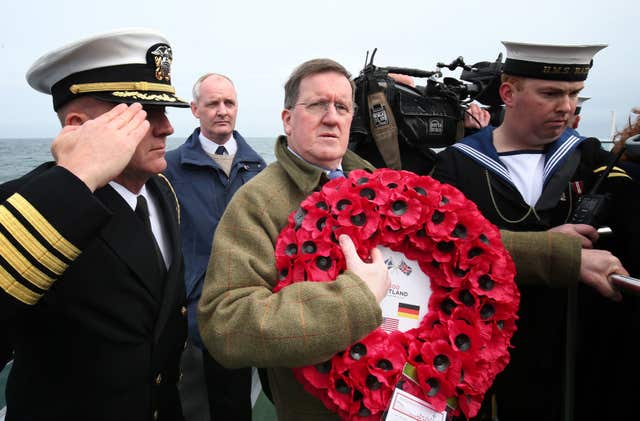 Lord George Robertson holds a wreath prior to throwing it in the sea close to the wreck of SS Tuscania (PA/Jane Barlow)