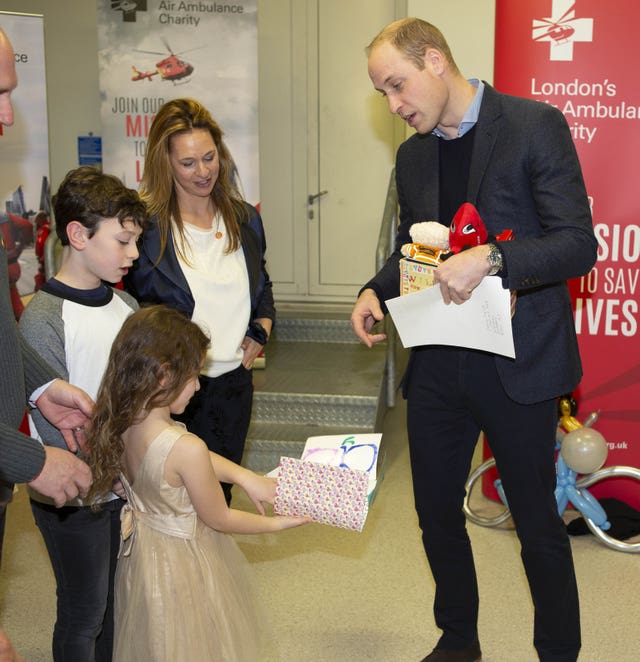 The Duke of Cambridge meets Yair Shahar and his daughter, who gave the duke a birthday card for the Duchess of Cambridge, during a visit to the Royal London Hospital
