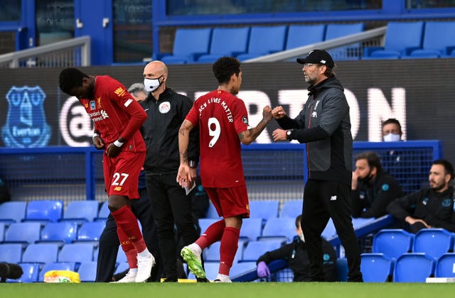 Liverpool manager Jurgen Klopp fistbumps Roberto Firmino as he is replaced by Divock Origi 