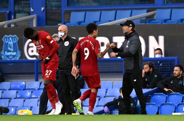 Liverpool manager Jurgen Klopp fistbumps Roberto Firmino as he is replaced by Divock Origi