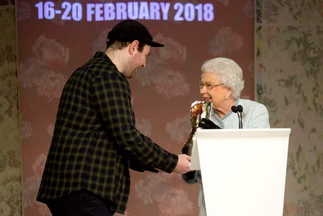 The Queen presents the inaugural Queen Elizabeth II Award for British Design to Richard Quinn following his Autumn/Winter 2018 London Fashion Week (Isabel Infantes/PA)