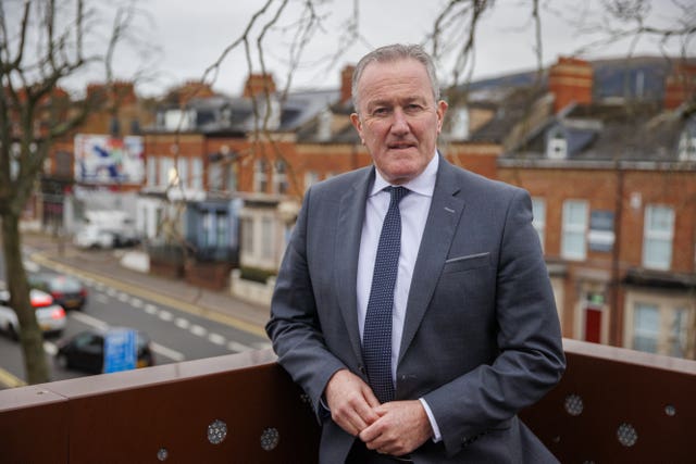 Conor Murphy looks at the camera while standing on a building roof space